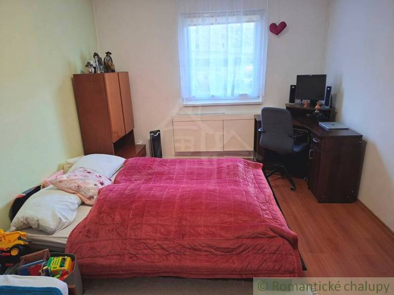 Hálószoba családi házban ággyal, íróasztallal és fa dekoros padlóval.