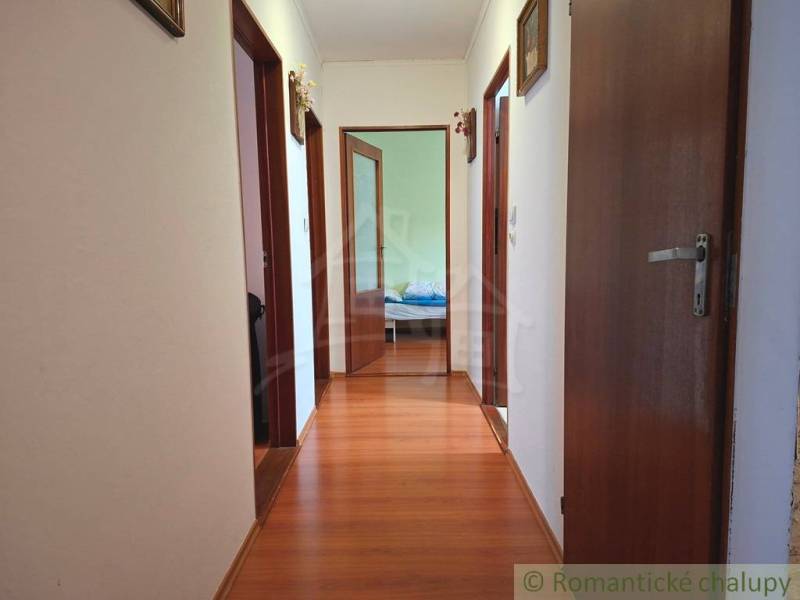 Folyosó fa dekorációval a padlón a családi házban, szobák bejárata.