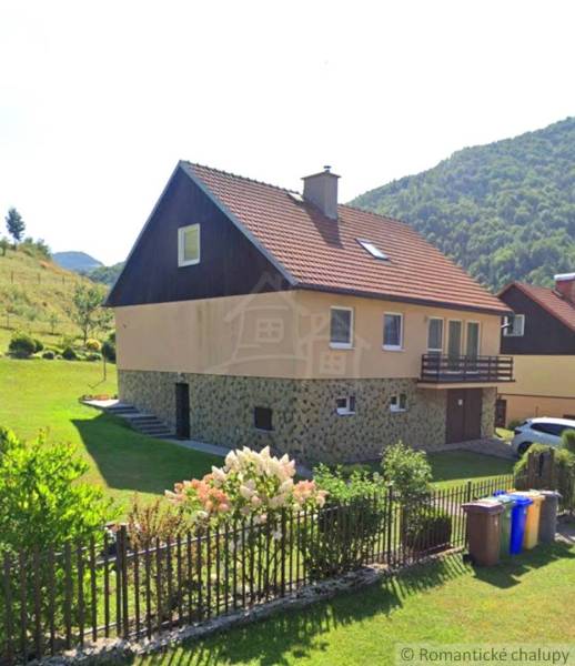 Családi ház Liptovské Revúcéban piros tetővel, kerttel és virágos kerítéssel.