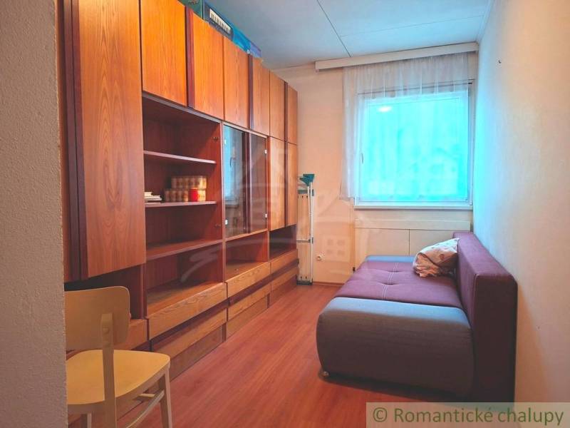 Szoba kanapéval, szekrényekkel és fa dekorációjú padlóval egy családi házban.