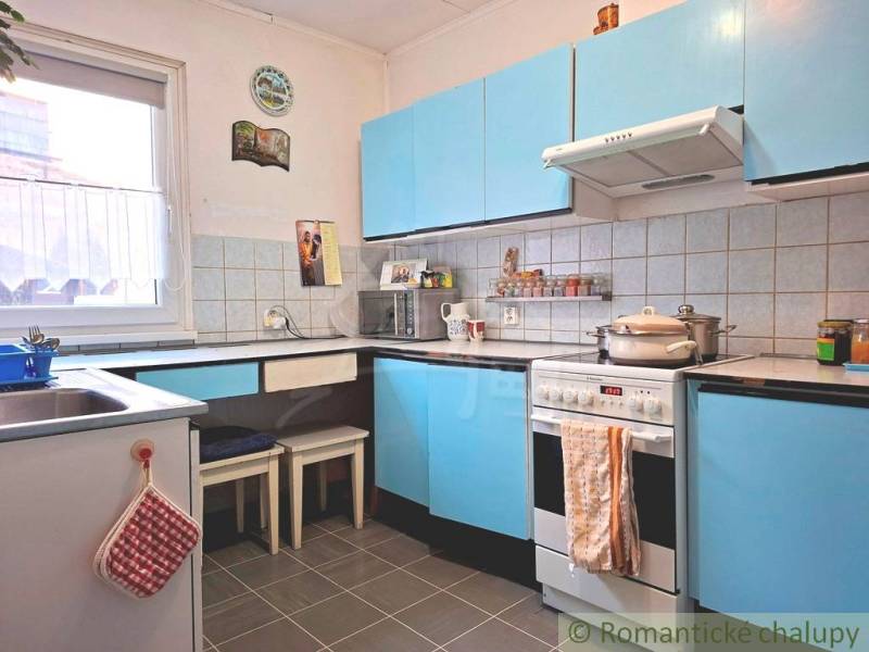 Konyha családi házban kék szekrényekkel és csempézett fallal.