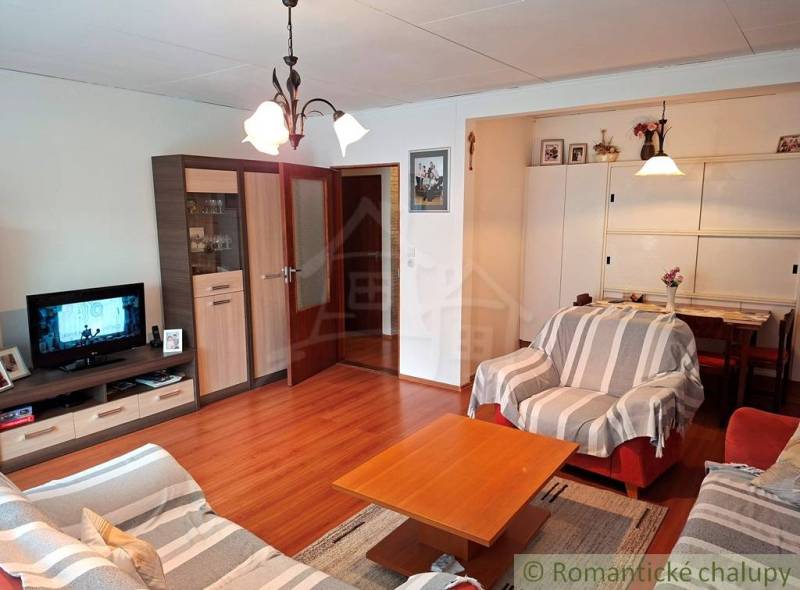 Nappali egy családi házban kényelmes kanapékkal és fa dekorációjú padlóval.