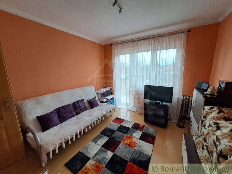 Nappali egy családi házban, fa dekorációjú padlóval és narancssárga falakkal.