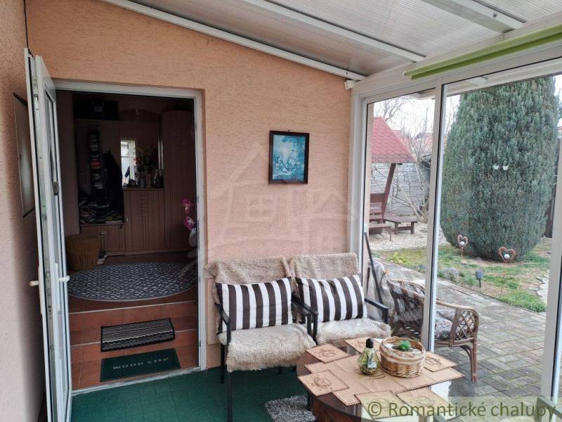 Téli kert a családi házban kényelmes ülőhellyel és kilátással a kertre.