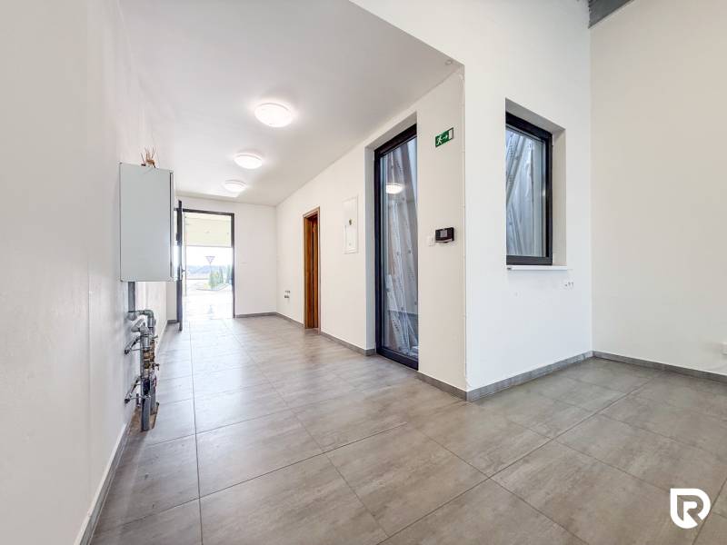 Egy üzlethelyiség belső tere csempézett padlóval és üvegajtókkal.