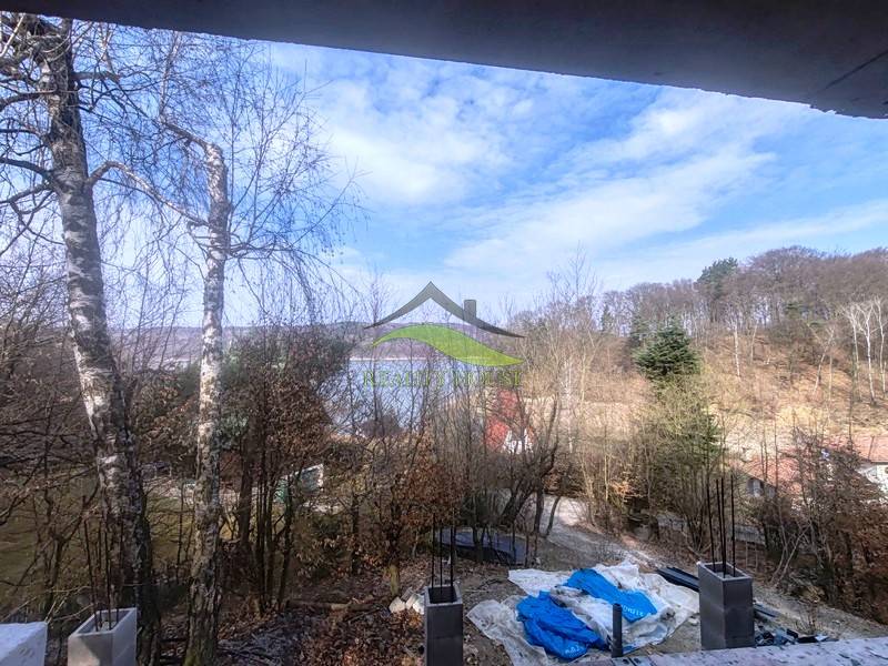 Kilátás a tóra a Holčíkovce-i Nyúlvölgyi Faházból, amelyet erdő vesz körül.