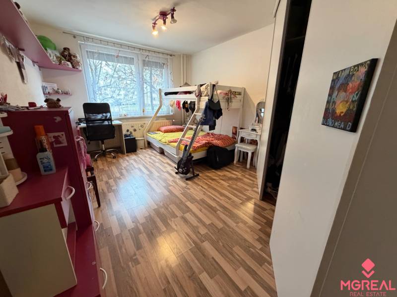 Gyerekszoba fa mintázatú padlóval, emeletes ággyal és íróasztallal.