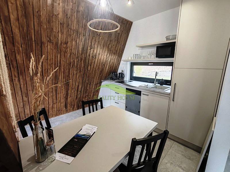 Konyha fahatású padlóval, fa falakkal és modern felszereléssel rendelkező házikóban.