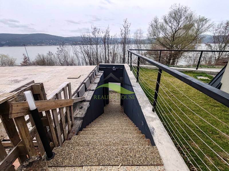 Külső tér Holčíkovce-ban az Eva utcán, kilátással a tóra és lépcsővel.