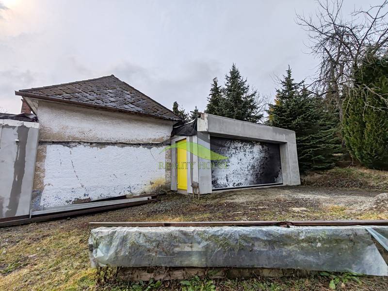 Családi ház a Piskoróc főutcáján, fákkal és fűvel körülvéve.