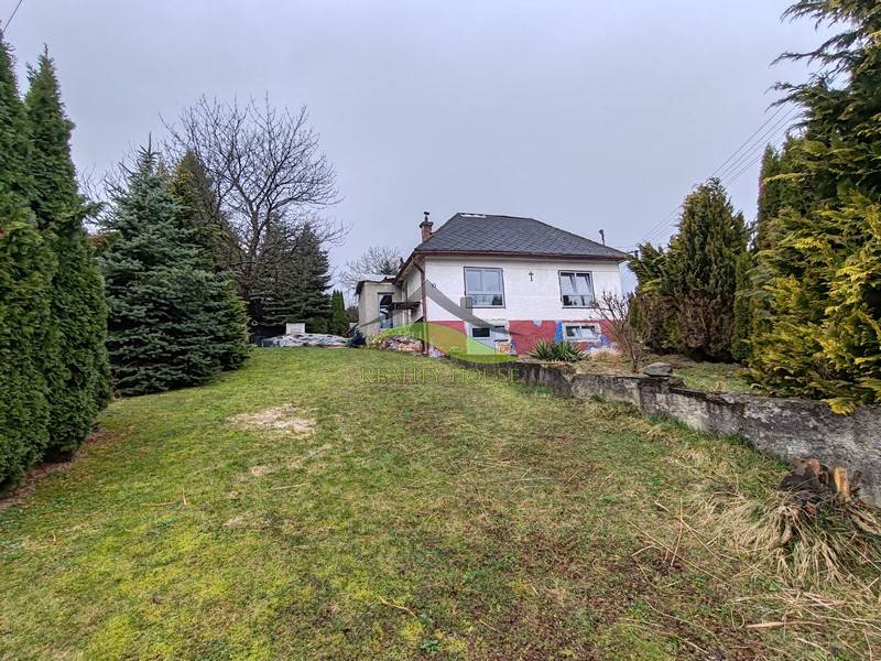 Családi ház a Fő utcán, Piskorócon, fákkal körülvéve és füves udvarral.