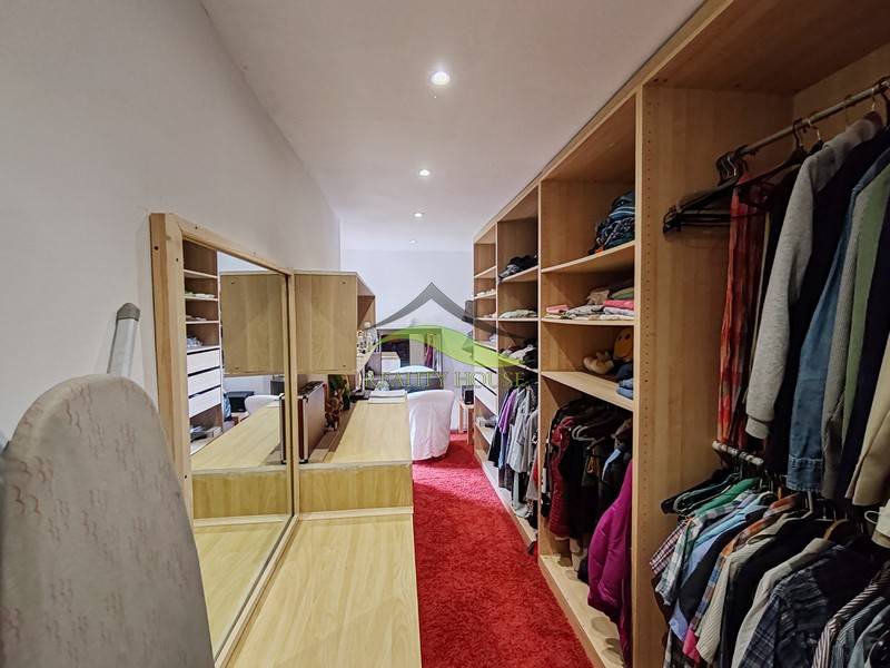 Gardrób családi házban piros szőnyeggel és beépített polcokkal.