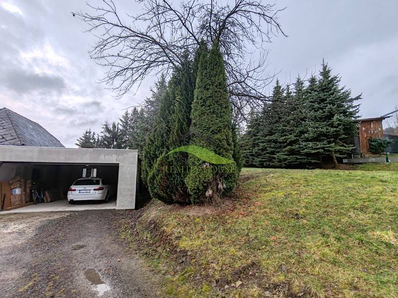 A Piskorovce-i Fő utcán található családi ház garázsát tűlevelűek veszik körül.