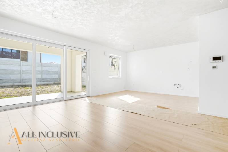 Világos nappali egy háromszobás lakásban, fa dekorációjú padlóval.