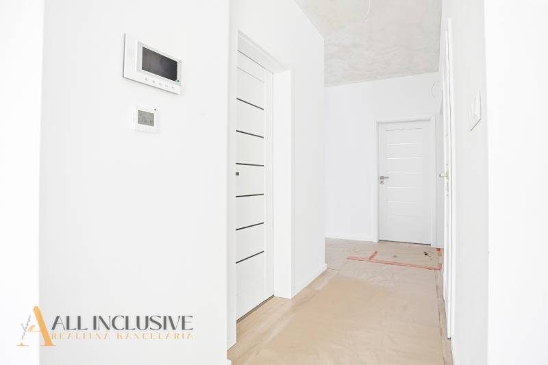 Fehér belső tér egy lakásban ajtókkal és beépített technológiákkal egy háromszobás lakásban.