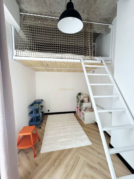 Gyerekszoba egy háromszobás lakásban emeletes ággyal és fa dekor padlóval.