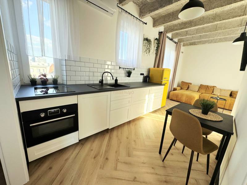 Konyha fehér szekrényekkel, színes hűtőszekrénnyel és fa dekoros padlóval.