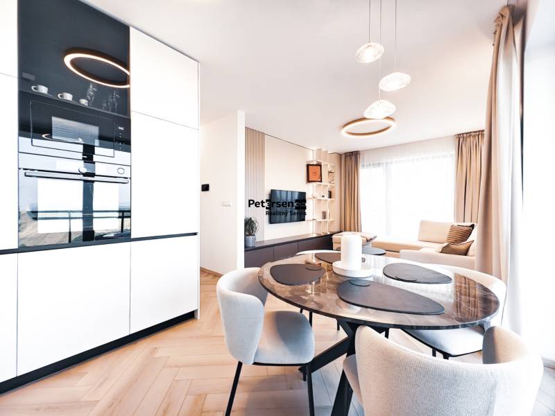 Kétszobás lakás étkezőasztallal, kanapéval és fa dekorációjú padlóval.