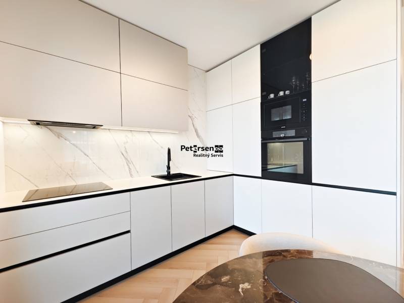 Konyha egy kétszobás lakásban fehér szekrényekkel és fa dekoros padlóval.