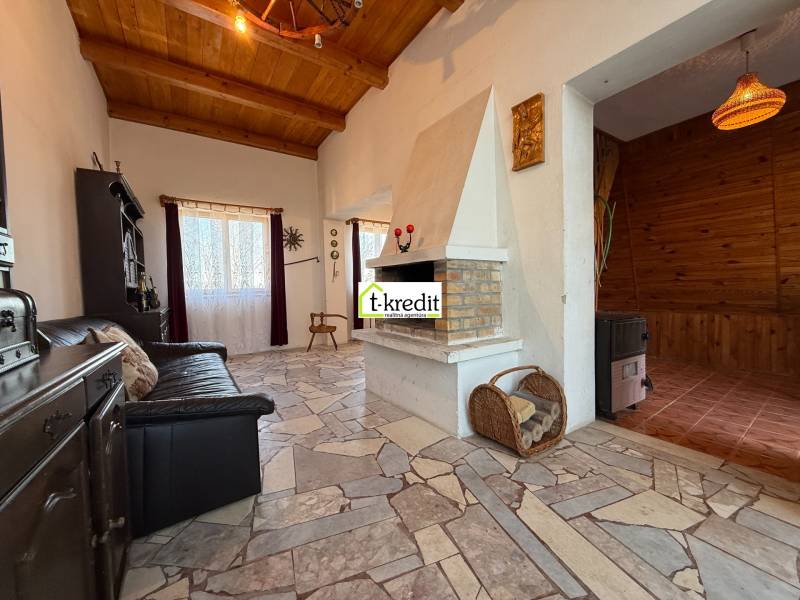 Kandallós ház, kényelmes kanapéval és fa mintázatú padlóval.