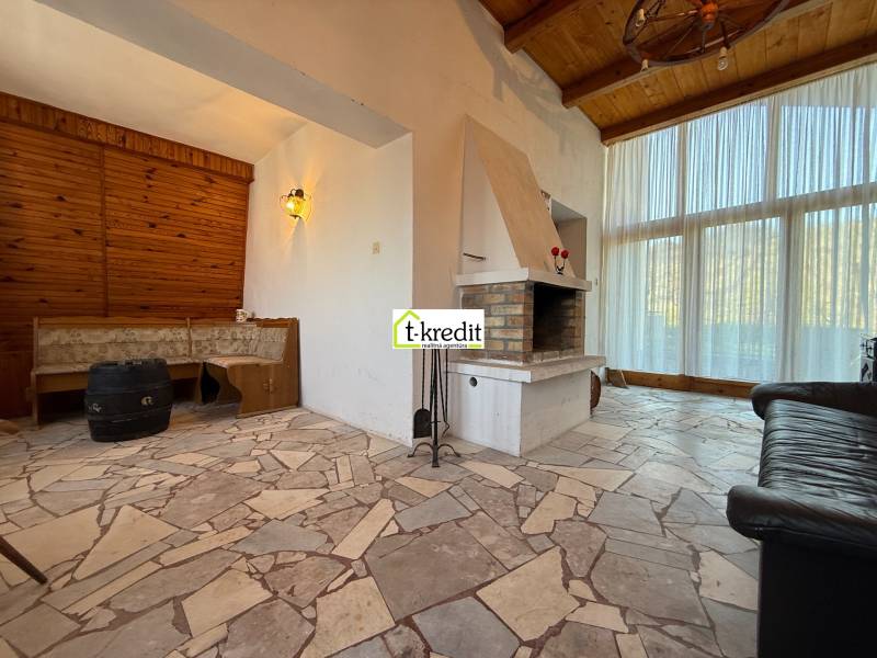 Egy kandallóval és ülőhellyel rendelkező faház belső tere, kőpadlóval.