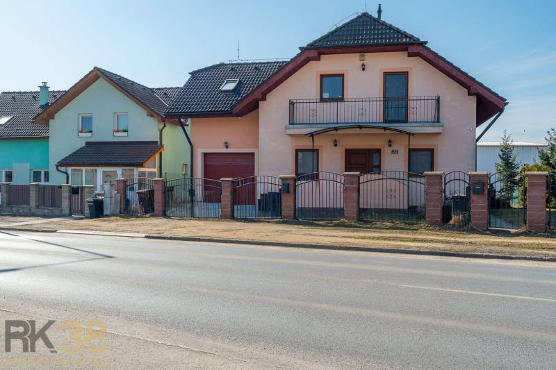 Családi ház Poprádon, két emelettel, garázzsal és erkéllyel, téglából készült kerítéssel.