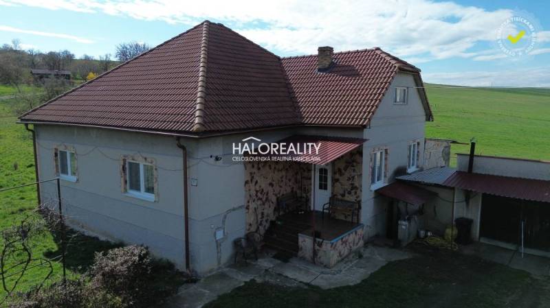 Családi ház Rimajánosiban piros tetővel és vidéki környezettel.