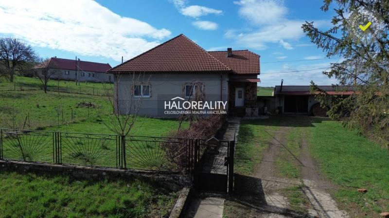 Családi ház Rimajánosiban, zöld gyepes telken, kerítéssel.