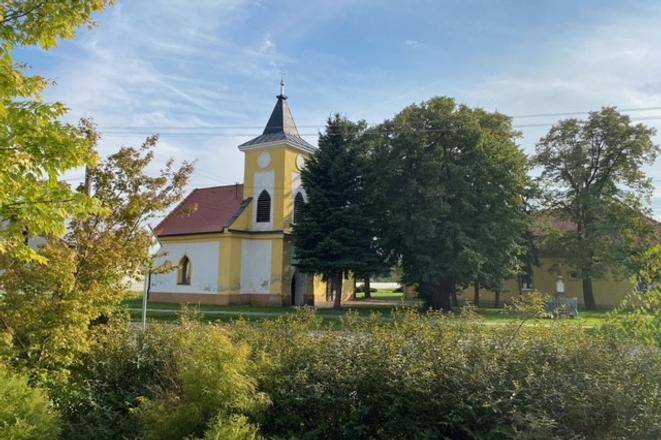 Egy templom zölddel körülvéve Práznovce mezőgazdasági és erdészeti területein.