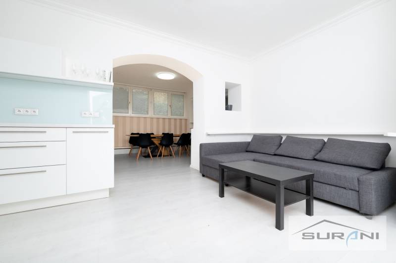 Nappali egy négy szobás lakásban konyhasarokkal és ülőgarnitúrával.