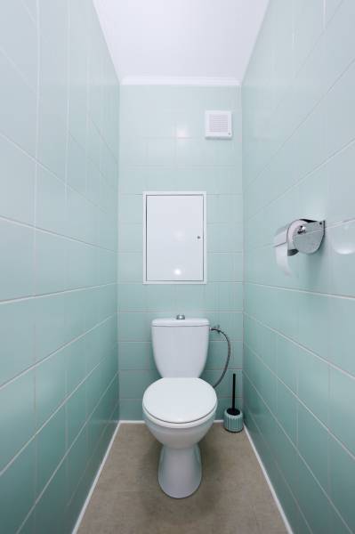 WC egy háromszobás lakásban világoskék csempével és világos színű padlóval.