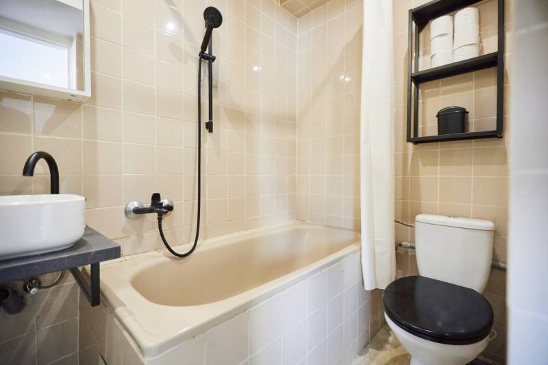 Fürdőszoba káddal, mosdóval, zuhanyzóval és WC-vel egy kétszobás lakásban.