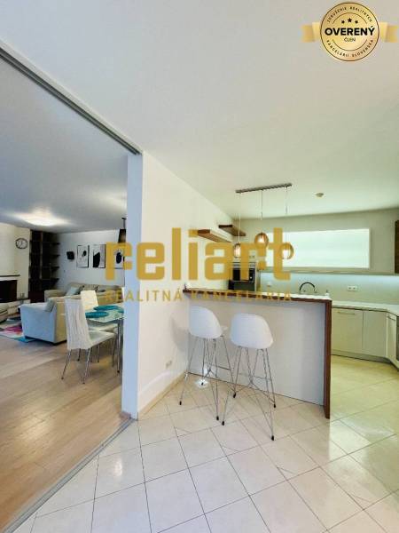 Konyha és nappali családi házban bárpulttal és székekkel.