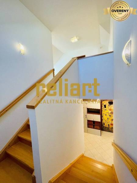 Családi ház belső tere lépcsővel és fa dekorációjú padlóval.