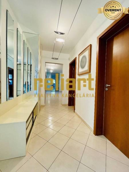 Folyosó egy családi házban csempével, tükrös fallal és faajtókkal.