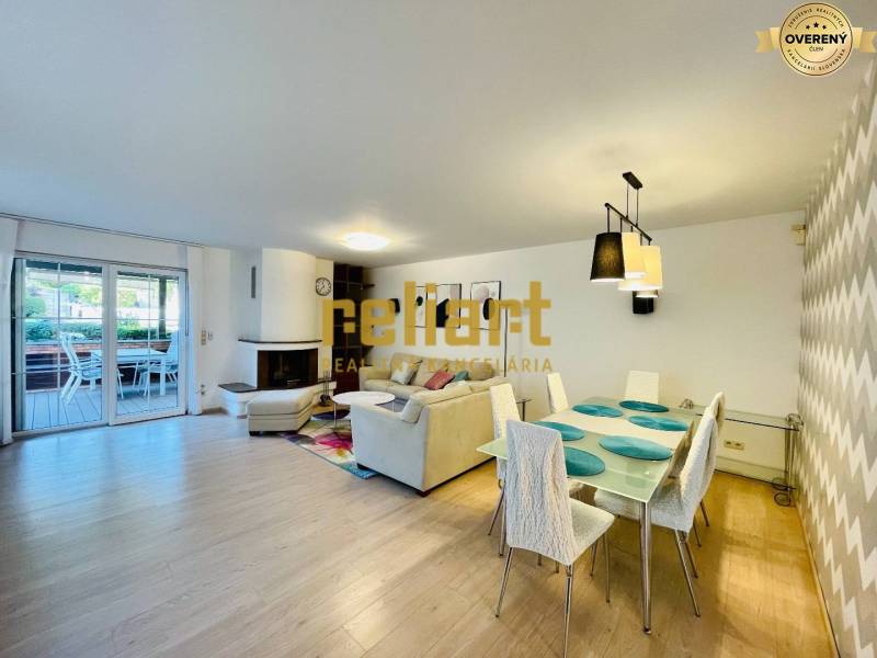 Családi ház belső tere kandallóval, fa dekorációjú padlóval és étkezőasztallal.