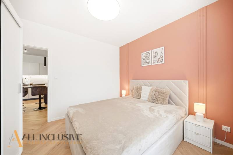 Hálószoba egy 4 szobás lakásban, fa dekorációjú padlóval és meleg tónusokkal.