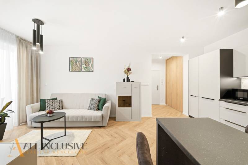 Nappali egy négy szobás lakásban, fa dekoros padlóval és minimalista dekorációval.