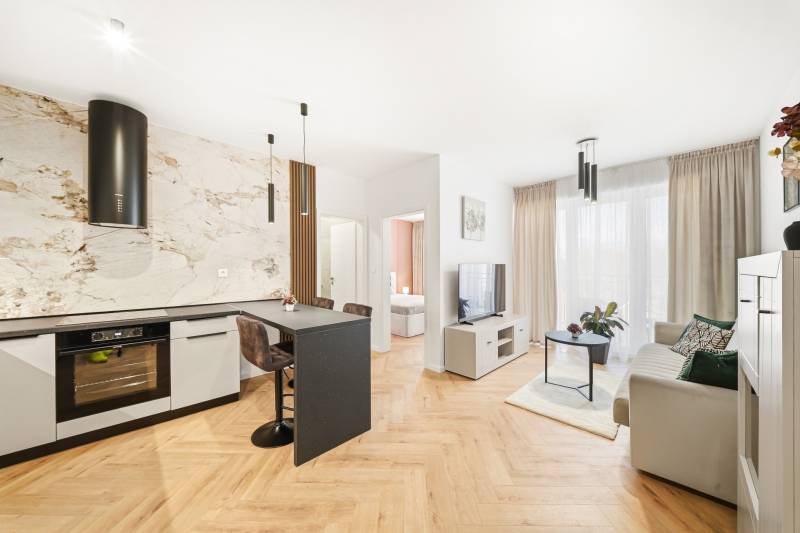 4 szobás lakás belső tere konyhával és nappalival, fa mintázatú padlóval.