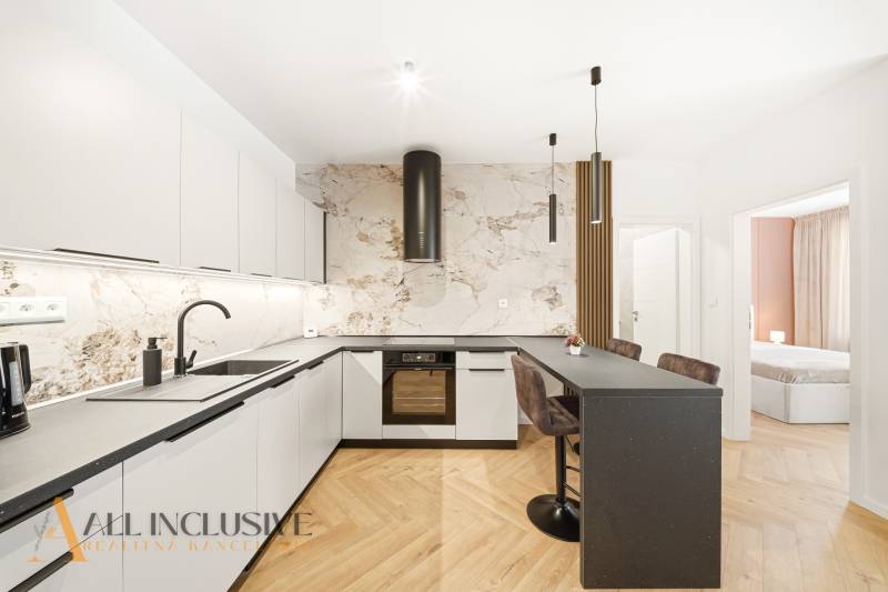 Konyha pulttal és fa mintázatú padlóval egy 4 szobás lakásban.