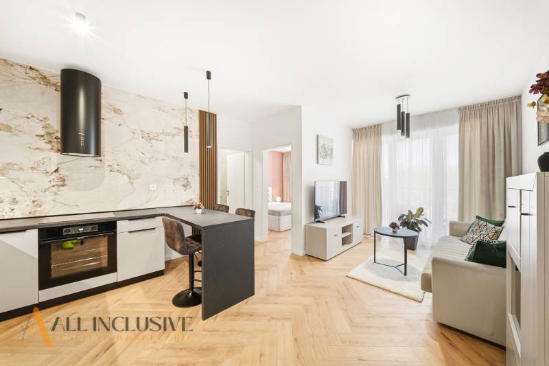 Nappali és konyha egy 4 szobás lakásban, fa dekorációjú padlóval és világos díszítéssel.