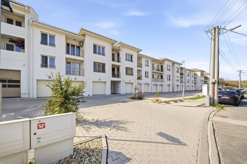 4 szobás lakás Dunaszerdahelyen világos homlokzattal és garázsokkal.