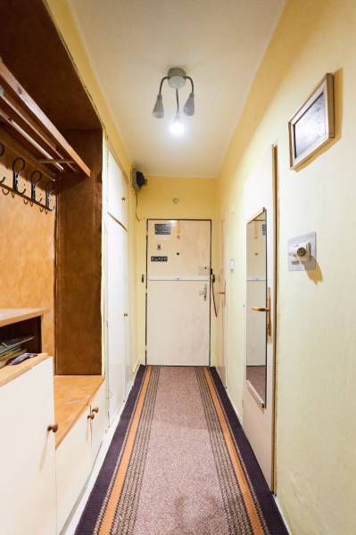 Előszoba egy 3 szobás lakásban fogassal, tükörrel és egyszerű világítással.