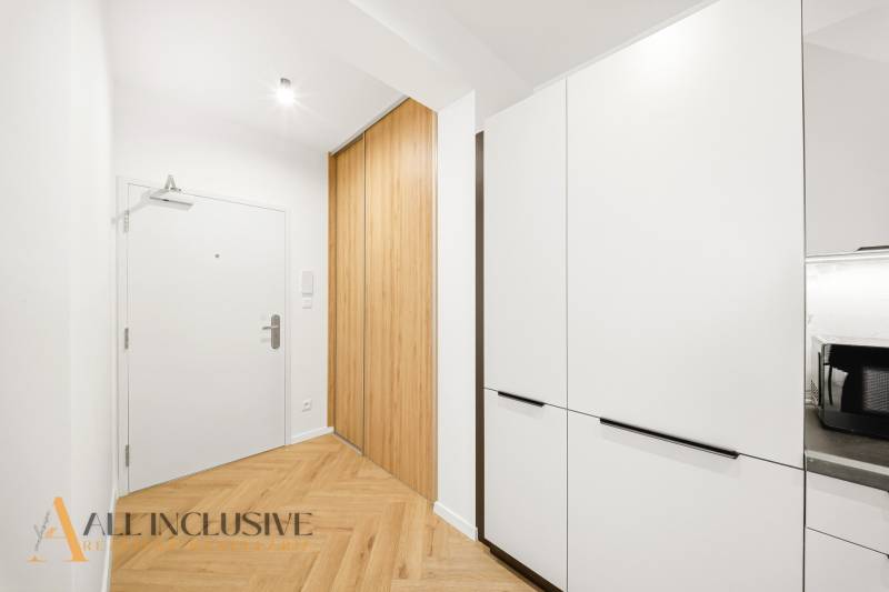 Előszoba egy 4 szobás lakásban, fa dekor padlóval és beépített szekrényekkel.