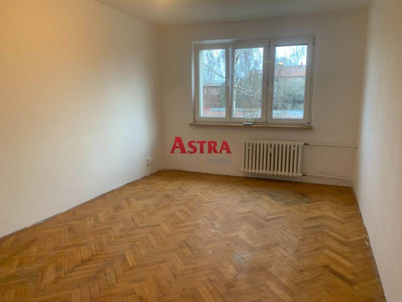 Szoba egy kétszobás lakásban fa dekoros padlóval és nagy ablakkal.