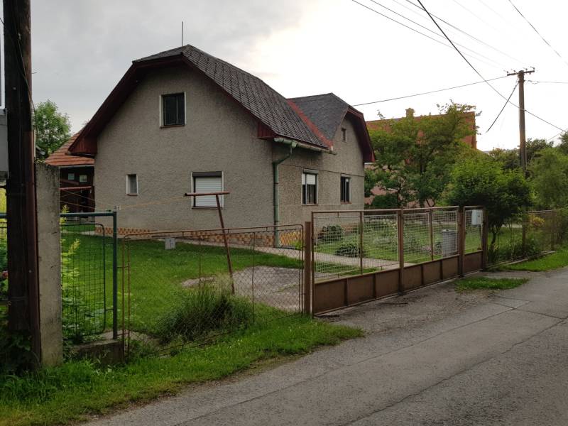 Családi ház Blatnica utcában, Blatnica városában, egyszerű kerttel és fém kerítéssel.