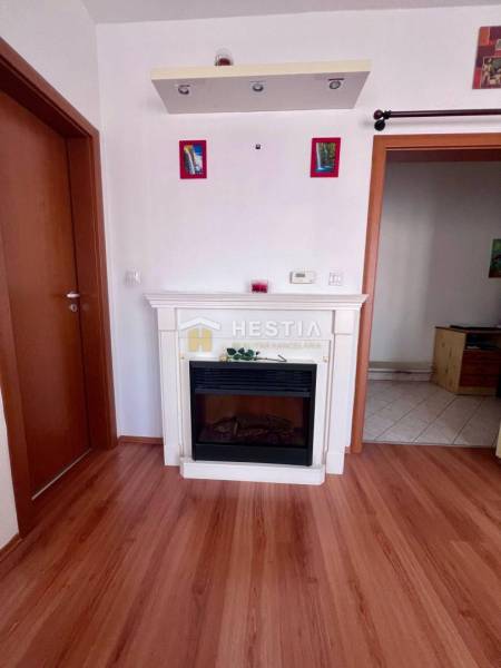 Kandalló fa padlóval és ajtókkal, egy egyszobás lakásban elhelyezve.