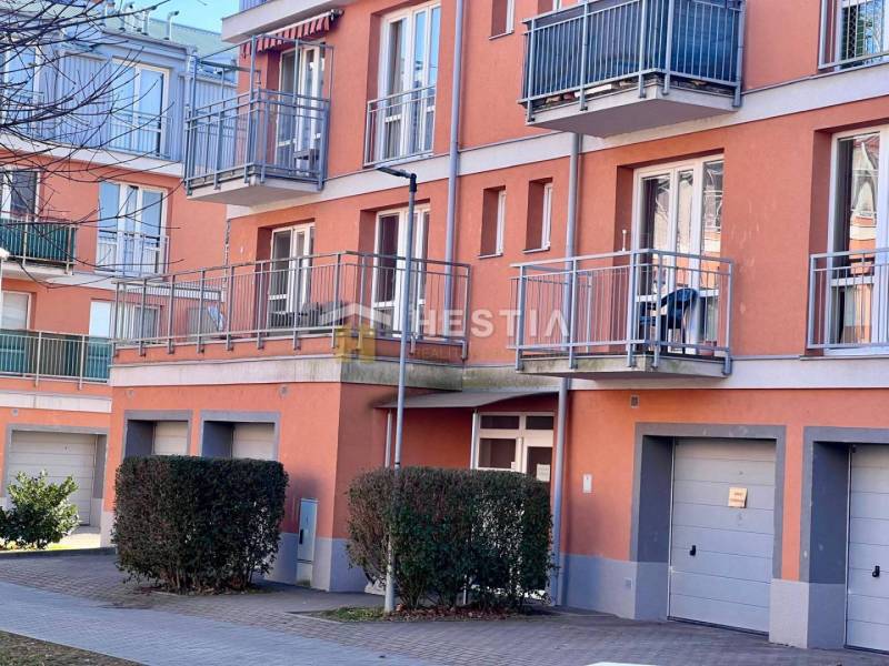 A kép egy lakóház külsejét ábrázolja erkélyekkel és garázsokkal egy egyszobás lakásban.