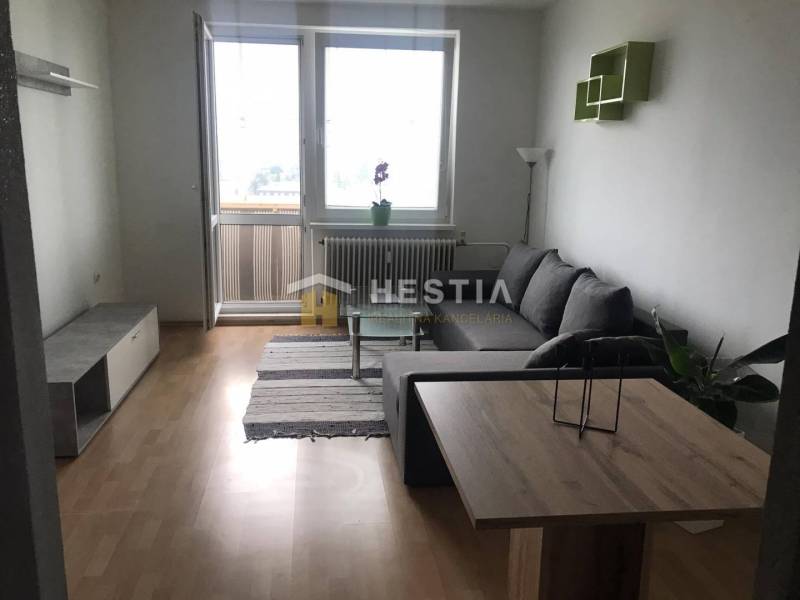 Nappali egy kétszobás lakásban, fa dekoros padlóval és kanapéval.