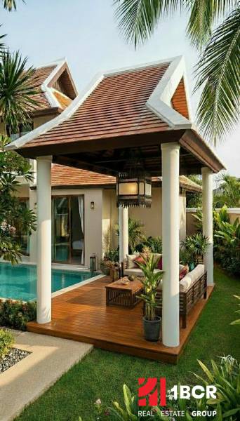 Villa Pattayában medencével és fa dekorációjú padlós terasszal.
